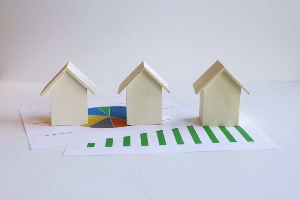 Small house models on financial documents representing cap rate and commercial real estate investment returns