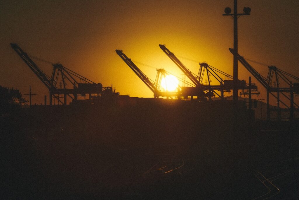 Silhouette of shipping crane at sunset at the Port of Oakland representing East Bay industrial property broker opinion of value