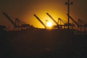 Silhouette of shipping crane at sunset at the Port of Oakland representing East Bay industrial property broker opinion of value