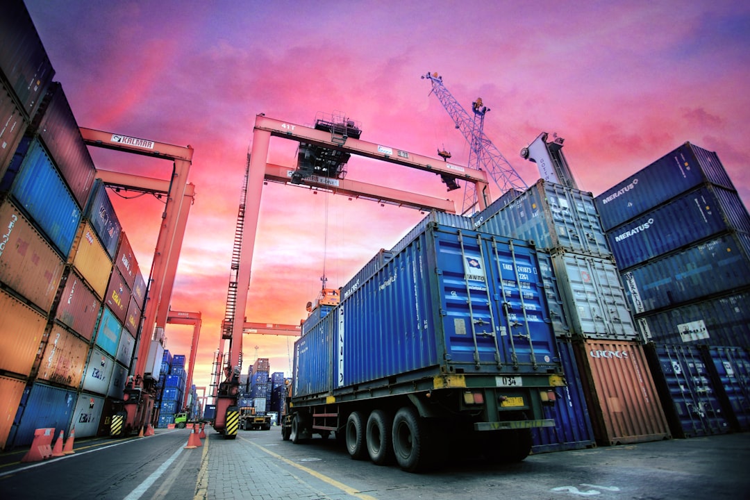 Shipping containers stacked at a busy port representing East Bay industrial property broker opinion of value